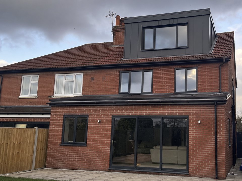 Rear of a semi with a clad loft dormer above a brick extension