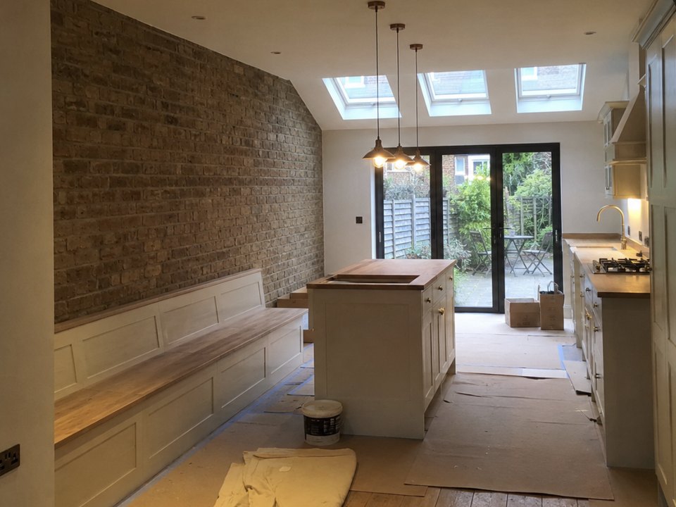 Kitchen extension with an exposed brick wall and roof lights